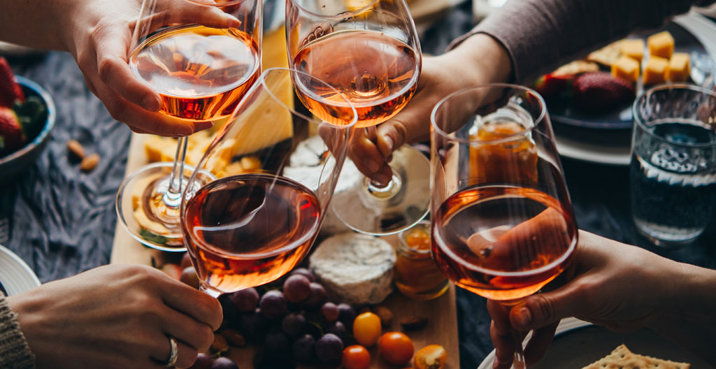 Plusieurs verres à vin rangés sur une étagère en bois dans une cuisine, lumière naturelle